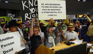 Protesters take over the City Council meeting, Monday May 5, 2014, in Albuquerque, N.M.  Alan Gomez was fatally shot by an APD officer in 2011. (AP Photo/The Albuquerque Journal, Bob Brawdy)