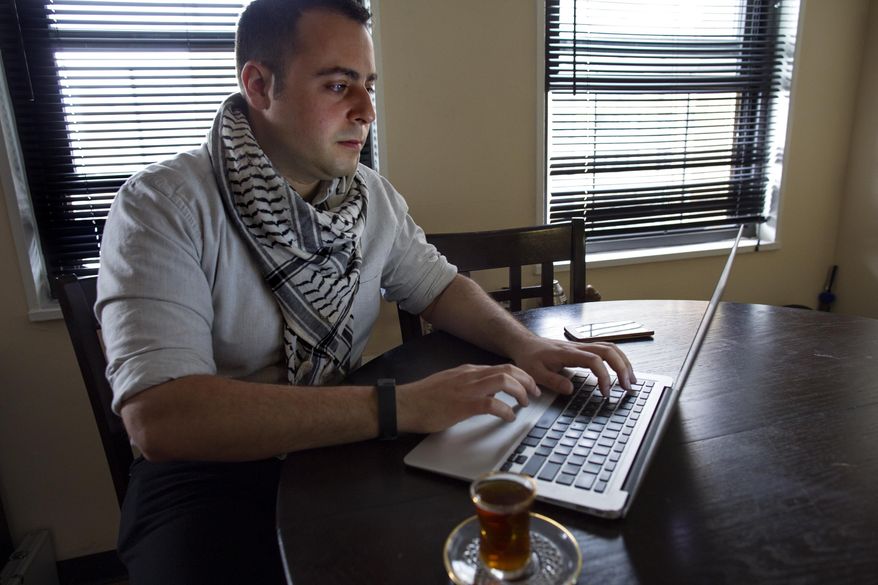 In this Sunday, May 4, 2014 photo, Bashar Makhay answers messages on a computer in his apartment in the Brooklyn borough of New York. Makhay, who is Iraqi-American, Catholic and gay, said he has created Tarab, a series of parties, beach gatherings and other events for LGBT Arabs and Middle Easterners in New York City. The Tarab program will celebrate its second anniversary with an event May 10. (AP Photo/Craig Ruttle)