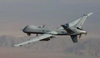 An MQ-9 Reaper patrols the skies with GBU-12 Paveway II laser guided munitions and AGM-114 Hellfire missiles. (U.S. Air Force) ** FILE **