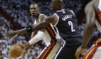 Miami Heat&#x27;s Chris Bosh, left, passes as Brooklyn Nets&#x27; Kevin Garnett (2) defends in the first half of Game 1 in an Eastern Conference semifinal basketball game, Tuesday, May 6, 2014, in Miami. The Heat defeated the Nets 107-86. Bosh scored 15 points and grabbed 11 rebounds. (AP Photo/Lynne Sladky)