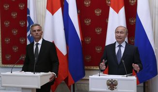 Russian President Vladimir Putin, right, and Swiss Federal President Didier Burkhalter hold a joint news conference in the Kremlin in Moscow, Wednesday, May 7, 2014. Russia has pulled back its troops from the Ukrainian border, Vladimir Putin told diplomats Wednesday as he urged insurgents in southeast Ukraine to postpone their planned referendum Sunday on autonomy. (AP Photo/Sergei Karpukhin, Pool)