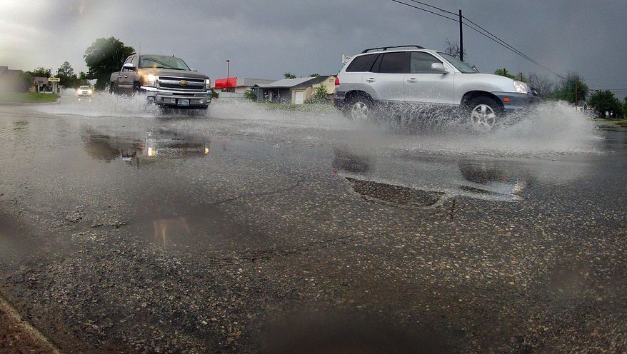 Vehicles drive along wet conditions on Thursday, May 8, 2014 in Wichita Falls, Texas. North Texans woke up Thursday morning to the welcome sound of rain and a little thunder as a storm system moved across the area dropping approximately one-half inch of rain overnight and in the morning in Wichita Falls, Texas. The area is suffering from exceptional drought conditions. (AP Photo/Wichita Falls Times Record News, Torin Halsey)