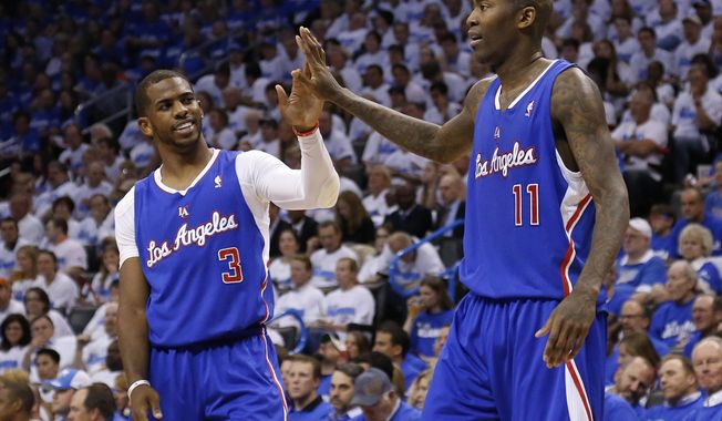 Los Angeles Clippers guard Chris Paul (3) high fives teammate Jamal Crawford (11) in the second quarter of Game 2 of the Western Conference semifinal NBA basketball playoff series against the Oklahoma City Thunder in Oklahoma City, Wednesday, May 7, 2014. (AP Photo/Sue Ogrocki)