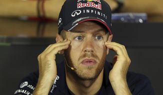 Red Bull driver Sebastian Vettel of Germany touches his temples during a news conference at the Catalunya racetrack in Montmelo, near Barcelona, Spain, Thursday, May 8, 2014. The Formula One race will be held on Sunday. (AP Photo/Luca Bruno)