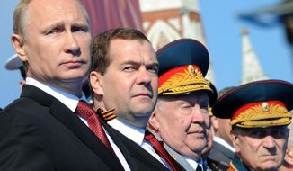 Russian President Vladimir Putin, left, and Prime Minister Dmitry Medvedev attend a Victory Day parade, which commemorates the 1945 defeat of Nazi Germany, at Red Square in Moscow, Russia, Friday, May 9, 2014. Russia marked the Victory Day on May 9 holding a military parade at Red Square. (AP Photo/RIA-Novosti, Mikhail Klimentyev, Presidential Press Service)