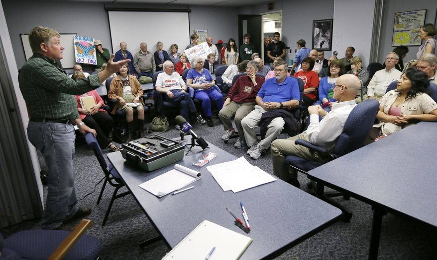 Iowa Department of Natural Resources Animal Feeding Operations Coordinator Gene Tinker, left, speaks during a DNR hearing on proposed new clean water rules, Friday, May 9, 2014, in Des Moines, Iowa. The Iowa DNR is facing criticism for proposing new livestock farm enforcement rules environmental groups and others say are not tough enough to clean up the state’s rivers and lakes. (AP Photo/Charlie Neibergall)
