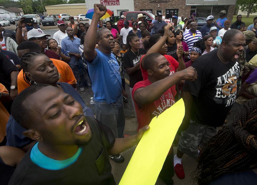Protesters chant during a rally outside the Hearne, Texas police department Thursday, May 8, 2014 following the Tuesday shooting of 93-year-old woman. Robertson County District Attorney Coty Siegert said Pearlie Golden was shot Tuesday night by Officer Stephen Stem. Stem was responding to a 911 call about a disturbance involving a woman with a gun. The Hearne Police Department says Golden "brandished a firearm" when Stem encountered her. He then shot her multiple times. The investigation into the shooting is being handled by the Texas Rangers. (AP Photo/Bryan College Station Eagle, Stuart Villanueva)