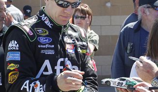 Driver Carl Edwards signs autographs  Friday, May 9, 2014, at Kansas Speedway in Kansas City, Kan., for Saturday night&#x27;s NASCAR Sprint Cup series auto race. (AP Photo/Colin E. Braley)