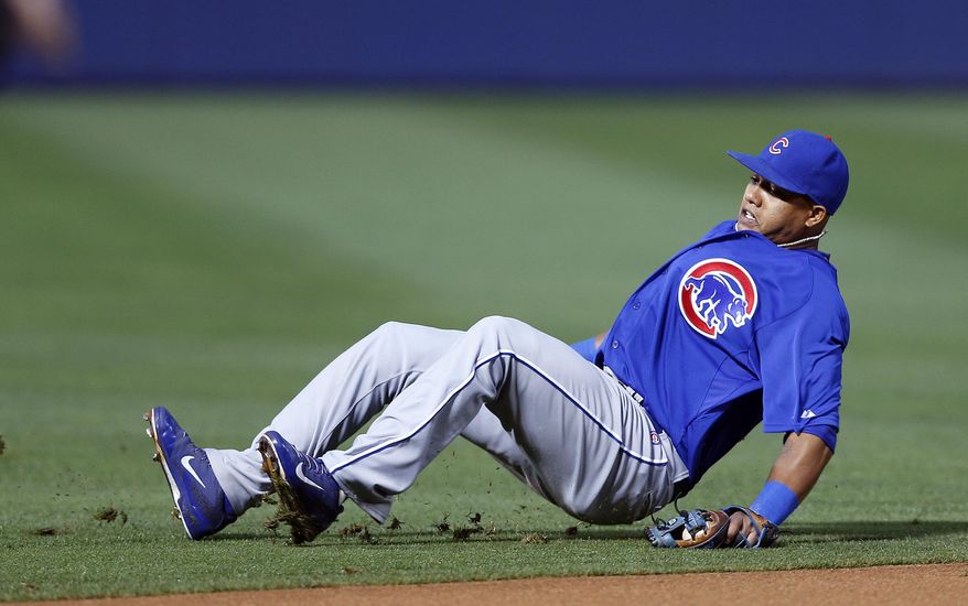 Chicago Cubs shortstop Starlin Castro slips as he attempts to field a ground ball hit by Atlanta Braves&#39; Chris Johnson in the first inning of a baseball game on Friday, May 9, 2014, in Atlanta. Johnson was credited with a base hit. (AP Photo/John Bazemore)