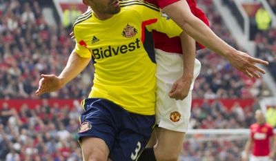 Manchester United&#39;s Phil Jones, right, fights for the ball against Sunderland&#39;s Fabio Borini, during their English Premier League soccer match at Old Trafford Stadium, Manchester, England, Saturday May 3, 2014. (AP Photo/Jon Super)