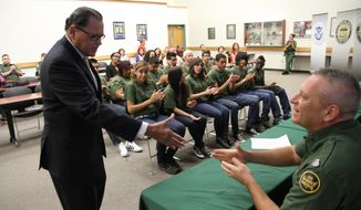 Texas state Sen. Jose Rodriguez greets Border Patrol Division Chief Michael Przybyl after addressing high school students that graduated from at-risk youth program at the Border Patrol station in El Paso, Texas, Friday, May 09, 2014. Twelve teenagers referred by truancy court graduated Friday from the five-week REAL program in which Border Patrol agents mentor them through physical training, community service and presentations at other local institutions like a jail tour.  (AP Photo/Juan Carlos Llorca)