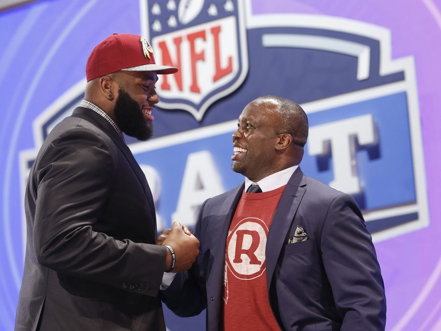 Virginia tackle Morgan Moses greets former Washington Redskins' linebacker London Fletcher after being selected by the Redskins as the 66th pick during the third round of the 2014 NFL Draft, Friday, May 9, 2014, in New York. (AP Photo/Jason DeCrow)
