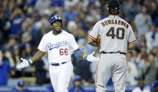 San Francisco Giants starting pitcher Madison Bumgarner, right, and Los Angeles Dodgers&#39; Yasiel Puig, left, exchange words as Puig runs down the third base line after hitting a solo home run during the sixth inning of a baseball game, Friday, May 9, 2014, in Los Angeles. (AP Photo/Danny Moloshok)