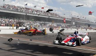 Sebastian Saavedra, left, of Colombia,  is hit by Mikhail Aleshin, of Russia, on the start of the inaugural Grand Prix of Indianapolis IndyCar auto race at the Indianapolis Motor Speedway in Indianapolis, Saturday, May 10, 2014. Takuma Sato, right, of Japan, drives past accident. (AP Photo/Robert Baker)