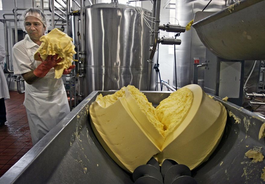 FILE - In this Aug. 9, 2006 file photo, Neal Baldwin scoops up butter with his hands to feed into a packaging machine at Organic Valley's creamery in Chaseburg, Wis. The federal government released new farm data this month that help illustrate changes in how the nation’s food is produced. Wisconsin had 1,180 organic farms in 2012, more than any other state except California. Nearly one in five was in Vernon County, home of Organic Valley, the nation’s top seller of organic milk. (AP Photo/Milwaukee Journal Sentinel, Gary Porter, File)