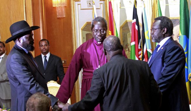 South Sudan&#x27;s President Salva Kiir, left, and rebel leader Riek Machar, right, shake hands and pray before signing an agreement of the cease-fire of the conflict in South Sudan in Addis Ababa, Ethiopia,  Friday, May 9, 2014. (AP Photo/Elias Asmare) ** FILE **