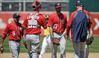 Washington Nationals starting pitcher Gio Gonzalez, center, is pulled from a baseball game during the fifth inning against the Oakland Athletics, Sunday, May 11, 2014, in Oakland, Calif. (AP Photo/Marcio Jose Sanchez)