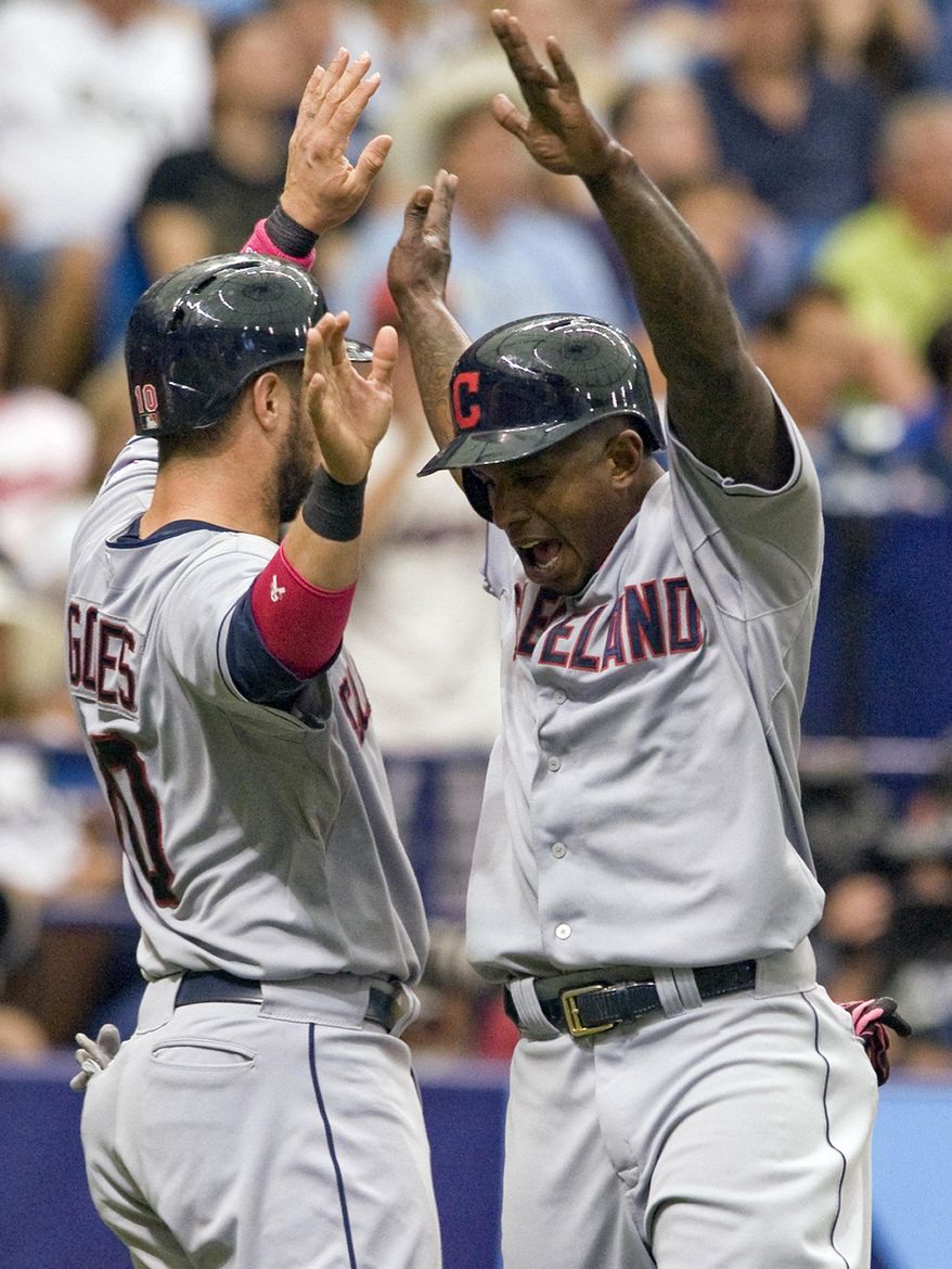 Cleveland Indians&#x27; Yan Gomes, left, and Nyjer Morgan, right, celebrate after scoring on Michael Bourn&#x27;s two-run double during the second inning of a baseball game against the Tampa Bay Rays, Sunday, May 11, 2014, in St. Petersburg, Fla. (AP Photo/Steve Nesius)