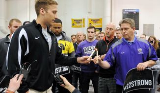 Minnesota State University, Mankato head football coach Todd Hoffner lights a candle held by former team member Sam Thompson, who said a few words at a candle light vigil held for former Minnesota State, Mankato, linebacker Isaac Dallas Kolstad, Sunday, May 11, 2014, in Mankato, Minn. Former Minnesota Gophers quarterback Philip Robert Nelson was jailed following an altercation in Mankato early Sunday that sent Kolstad to the hospital in critical condition. (AP Photo/The Mankato Free Press, John Cross)
