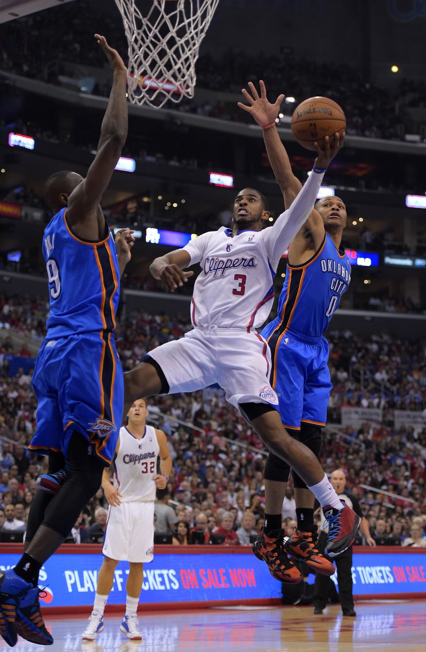 Los Angeles Clippers guard Chris Paul, center, puts up a shot between Oklahoma City Thunder defenders Serge Ibaka, left, of Congo, and Russell Westbrook in the first half of Game 4 of the Western Conference semifinal NBA basketball playoff series, Sunday, May 11, 2014, in Los Angeles. (AP Photo/Mark J. Terrill)