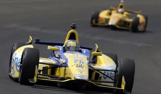 Marco Andretti leads Ryan Hunter-Reay through the first turn during practice for Indianapolis 500 IndyCar auto race at the Indianapolis Motor Speedway in Indianapolis, Monday, May 12, 2014. (AP Photo)