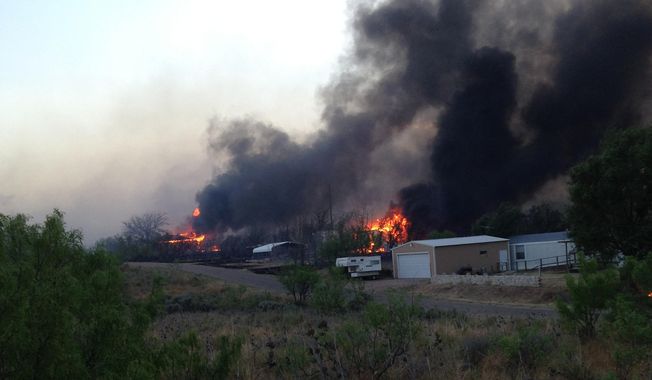 In this Sunday, May 11, 2014 photo provided by the Texas Department of Public Safety, a wildfire burns near Fritch, Texas. The wildfire has led to evacuations and road closures and has destroyed dozens of homes. (AP Photo/Texas Department of Public Safety, Chris Ray)