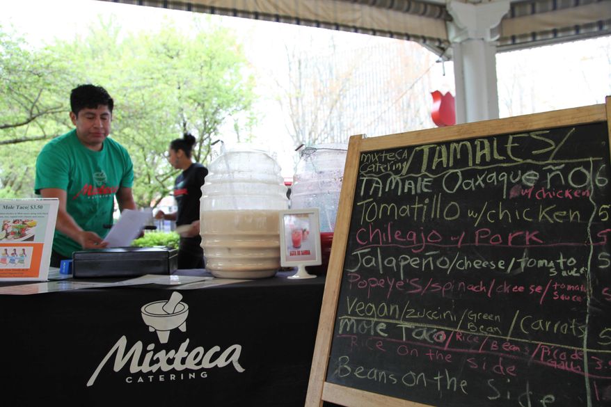 HOLD FOR MOVEMENT THURSDAY MAY 1 - In this photo Tuesday, April 15, 2014 photo, Gaudencio Felipe Asuncion prepares a traditional Oaxacan dish of tamales with mole sauce at the Lloyd Farmers Market in Portland, Oregon. The young man's mother, Paula Asuncion, started the food catering service after being part of a Portland micro-business development program for Spanish speakers run by Hacienda CDC. (AP Photo/Gosia Wozniacka)
