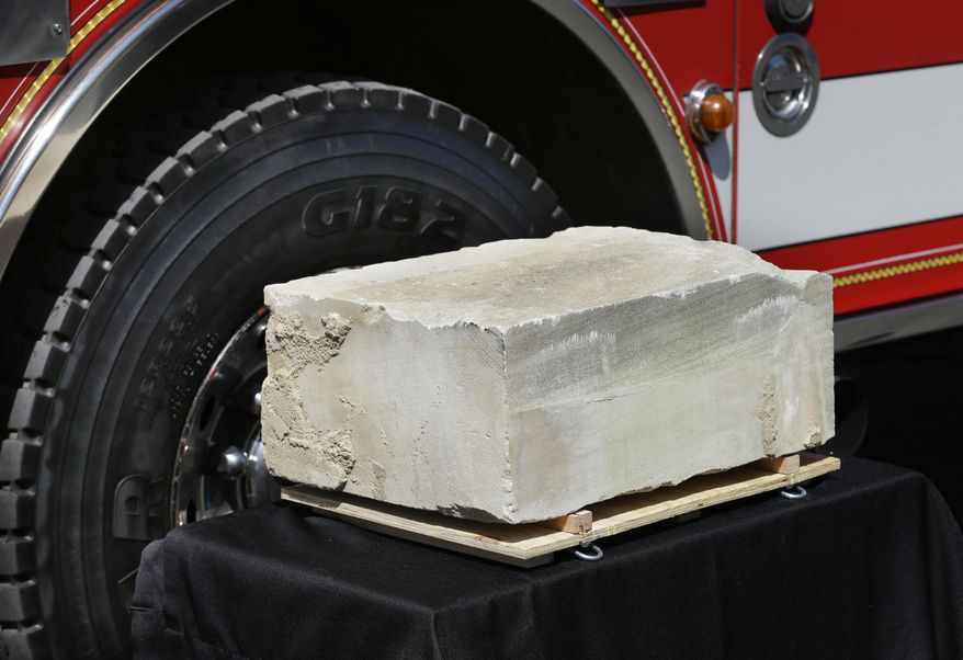A piece of limestone that was part of the building at the Pentagon in Washington, DC, before it was destroyed in the September 11, 2001 terrorist attacks is displayed Monday, May 12, 2014, at a delivery ceremony at the Alaska Airlines cargo facility in Seatac, Wash. The stone will be part of a Sept. 11th memorial in Federal Way, Wash. that will be dedicated on Sept. 11, 2014, and also contains a beam from the World Trade Center in New York and a rock from the field in Shanksville, Pa., where United flight 93 crashed during the attacks. (AP Photo)