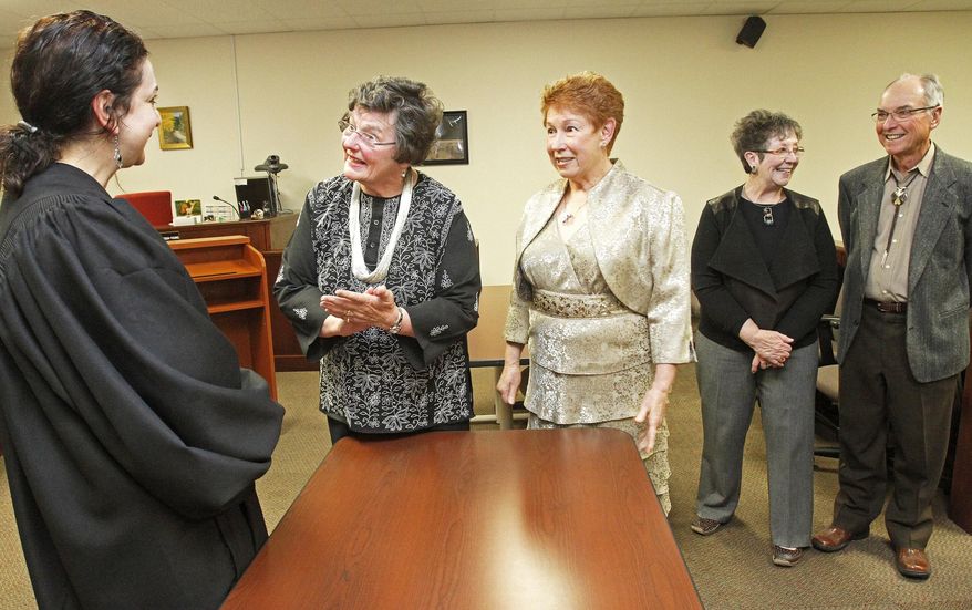 In this photo taken on Monday, May 12, 2014, Magistrate Judge, Donna Bevacqua Young, left, officiated the wedding of Kathy Chambery, center, and her partner of 23 years, Marilyn Haring, at Magistrate Court in Santa Fe, N.M. The Santa Fe residents became the 1,000th same-sex couple to receive a marriage license from Santa Fe County. (AP Photo/The Santa Fe New Mexican, Jane Phillips)