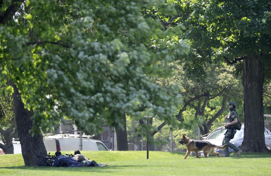 Police officers work outside WMAR-TV, after a truck driven by a man rammed the Baltimore-area television station Tuesday, May 13, 2014 leaving a gaping hole in the front of the building, in Towson, Md. Police were still searching for the driver. They said they didn't know of a motive and didn't find weapons in the truck, but they assumed the driver may be dangerous because he ran into the occupied building. The station believes everyone inside evacuated safely, News Director Kelly Groft said. (AP Photo/Steve Ruark)