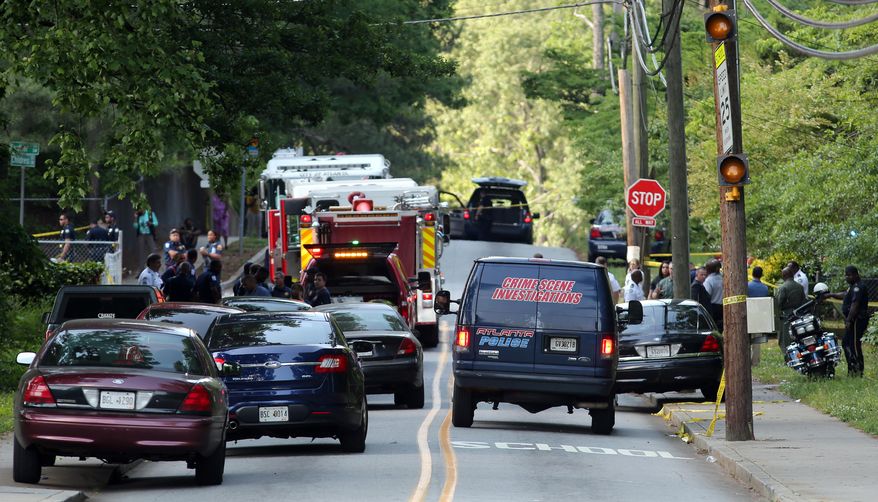Police investigate the scene of a shooting where five students were shot near Therrell High School in southwest Atlanta on Tuesday, May 13, 2014. Police said their injuries don't appear to be life-threatening and the incident didn't happen on school property. (AP Photo/The Atlanta Journal-Constitution, Ben Gray)