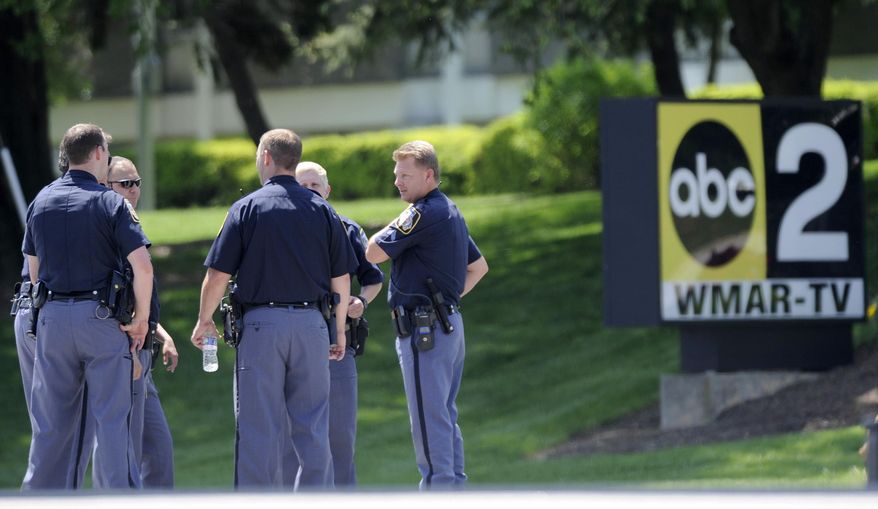 Police officers stand outside WMAR-TV, after a truck driven by a man rammed the Baltimore-area television station Tuesday, May 13, 2014 leaving a gaping hole in the front of the building, in Towson, Md. Police were still searching for the driver. They said they didn't know of a motive and didn't find weapons in the truck, but they assumed the driver may be dangerous because he ran into the occupied building. The station believes everyone inside evacuated safely, News Director Kelly Groft said. (AP Photo/Steve Ruark)