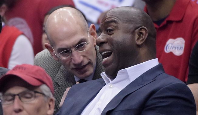 NBA Commissioner Adam Silver, left, talks with Magic Johnson as they watch the Los Angeles Clippers play the Oklahoma City Thunder in the first half of Game 4 of the Western Conference semifinal NBA basketball playoff series, Sunday, May 11, 2014, in Los Angeles. (AP Photo/Mark J. Terrill)