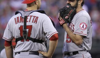 Los Angeles Angels catcher Chris Iannetta and pitcher Matt Shoemaker confer after Philadelphia Phillies&#39; Chase Utley hit a triple in the fourth inning of a baseball game, Tuesday, May 13, 2014, in Philadelphia. (AP Photo/Laurence Kesterson)