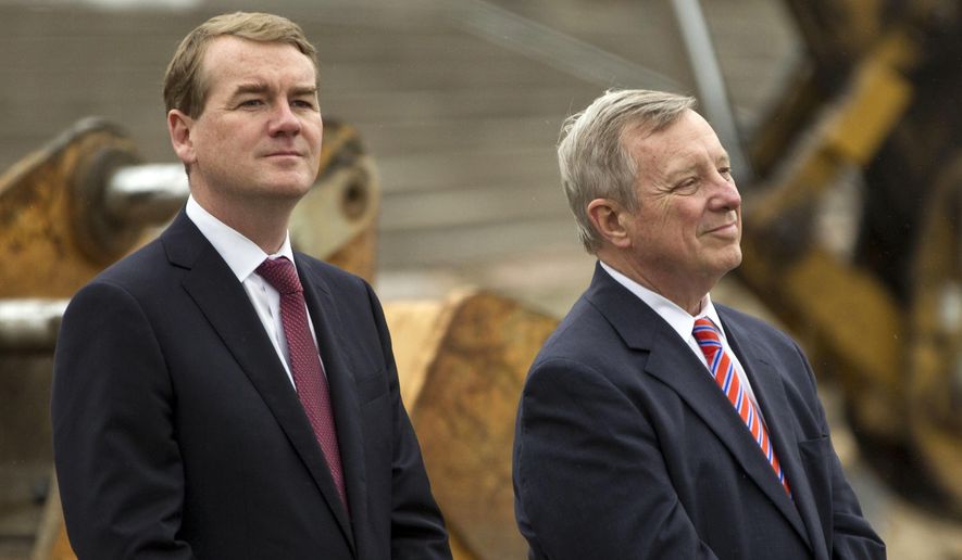 Sen. Michael Bennet, D-Colo., left, and Sen. Dick Durbin, D-Ill., listen as Vice President Joe Biden speaks during a visit to the CityArchRiver project at the Gateway Arch on Tuesday, May 13, 2014, in St. Louis. (AP Photo/Whitney Curtis)