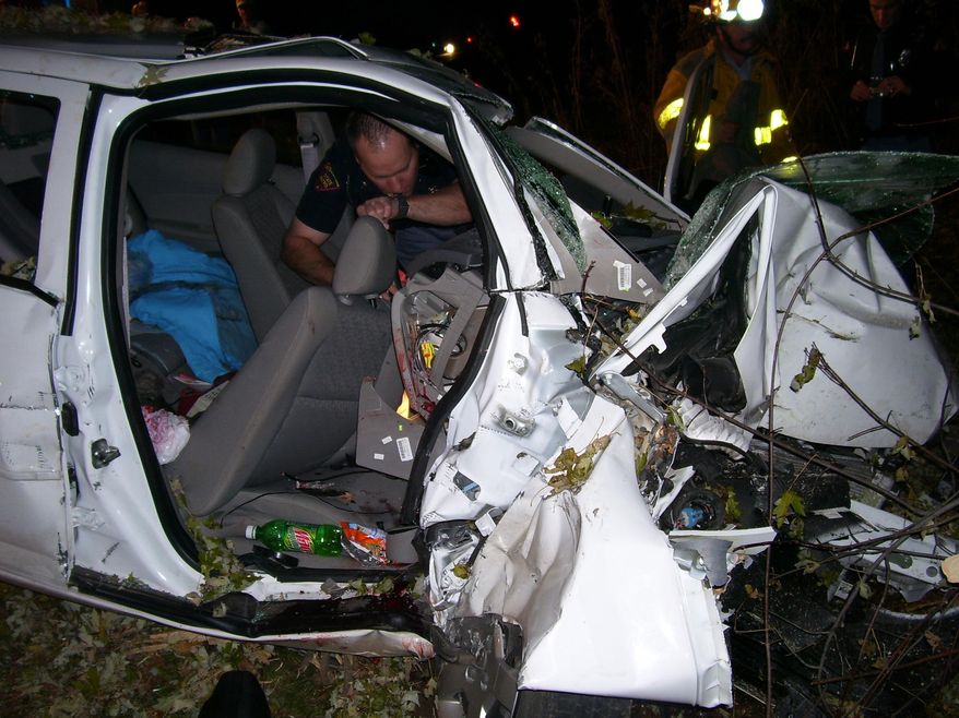 In this Oct. 24, 2006 photo provided by the St. Croix County Sheriff's Office, police investigate the wreckage of a 2005 Chevrolet Cobalt that crashed in St. Croix County, killing Natasha Weigel, 18, and Amy Lynn Rademaker, 15, and injuring the 17-year-old driver, Megan Ungar-Kerns. The vehicle's ignition was found in the “accessory” position and the air bags didn’t deploy. General Motors’ recent recall of 2.6 million small cars, including the 2005 Cobalt, has shed light on an unsettling fact: Air bags might not always deploy when drivers _ and federal regulators _ expect them to. (AP Photo/St. Croix County Sheriff's Office)