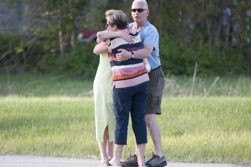 Neighborhood residents embrace after a police officer was fatally wounded and a home in Brentwood, N.H., Monday May 12, 2014. Brentwood police officer Steven Arkell was allegedly shot to death by Michael Nolan, when he answered a call in a Nolan's suburban neighborhood, according to the New Hampshire Attorney General Joseph Foster. (AP Photo/Foster's Daily Democrat, Ryan McBride)
