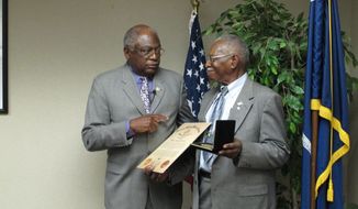 U.S. Rep. Jim Clyburn, D-S.C., left, presents a Congressional Gold Medal to William Ramseur, right on Wednesday, May 14, 2014, in Columbia, S.C. Ramseur, of Columbia, was a member of the Montford Point Marines who integrated the Marine Corps in the 1940s. (AP Photo)