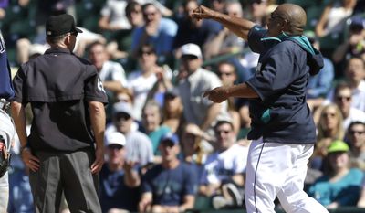 Seattle Mariners manager Lloyd McClendon, right, throws his cap after he was ejected by first base umpire Lance Barksdale, left, Wednesday, May 14, 2014, after McClendon argued the call that Mariners' John Buck had struck out swinging in the eighth inning of a baseball game against the Tampa Bay Rays, in Seattle. (AP Photo)