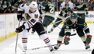 Chicago Blackhawks right wing Patrick Kane (88) and Minnesota Wild left wing Erik Haula (56), of Finland, chase the puck during the second period of Game 6 of an NHL hockey second-round playoff series in St. Paul, Minn., Tuesday, May 13, 2014. (AP Photo/Ann Heisenfelt)