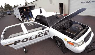 A Bend Police Department car, a former Cheney Wash. police car,  is photographed on May 8, 2014 in Bend, Ore.   Rick Campbell, the current commander of the Cheney Police Department, said the car grill used to be a patrol car that was taken off the vehicle line when a new motor caused the transmission to go bad. The car sat in the department’s surplus until 2009.  The department went ahead with the plan and sent the car to Spokane Community College, where students stripped it down to its frame in return for the car’s engine. From there, a local metal worker installed the grill and meat smoker. All together, Campbell said, the project cost the department about $10,000, paid for by grants.   (AP Photo/The Bulletin, Ryan Brennecke)