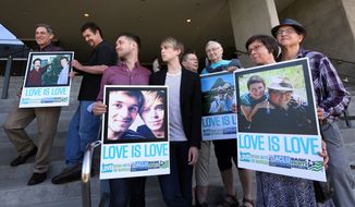 Supporters of same-sex marriage hold photos of themselves and their family members or partners on the steps of the Wayne L Morse U.S. Courthouse Wednesday, May 14, 2014, in Eugene, Ore. A federal judge will hear arguments Wednesday about whether a national group can defend Oregon&#39;s ban on same-sex marriage because the state&#39;s attorney general has refused to do so. (AP Photo/The Register-Guard, Chris Pietsch)