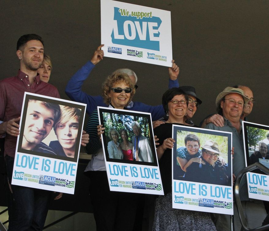 ** FILE ** Supporters of same-sex marriage hold photos of themselves and their family members or partners on the steps of the Wayne L Morse U.S. Courthouse Wednesday, May 14, 2014, in Eugene, Ore. A federal judge will hear arguments Wednesday about whether a national group can defend Oregon's ban on same-sex marriage because the state's attorney general has refused to do so. (AP Photo/The Register-Guard, Chris Pietsch)