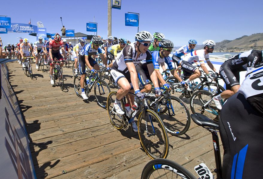 Riders head down the pier at the start of Stage 5 of the Tour of California cycling race in Pismo Beach, Calif., on Thursday, May 15, 2014. (AP Photo/The Tribune, Joe Johnston)