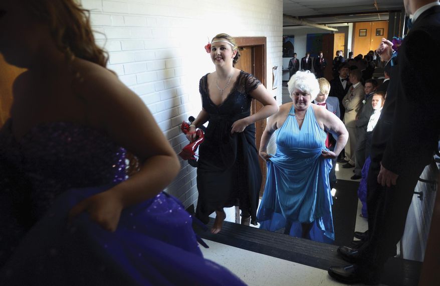 In this April 25, 2014 photo, Julie Stees, 59, starts the walk to the stage for the start of the grand march for the prom she attended with her 18-year-old grandson, Justin, at Prophetstown High School in Prophetstown, Ill. (AP Photo/Sauk Valley Media, Alex T. Paschal)