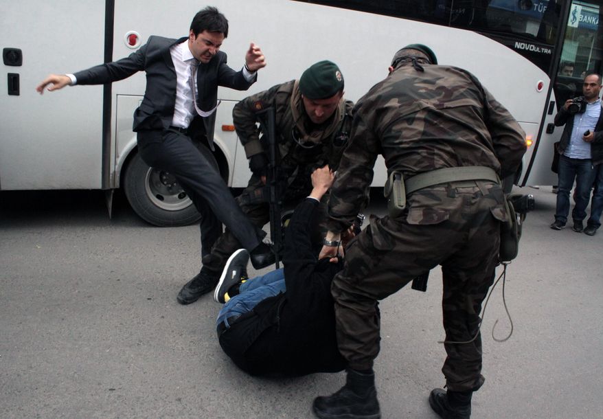 In this photo taken Wednesday, May 14, 2014  a person identified by Turkish media as Yusuf Yerkel, advisor to Turkish Prime Minister Recep Tayyip Erdogan, kicks a protester already held by special forces police members during Erdogan&#x27;s visiting  Soma, Turkey. Erdogan was visiting the western Turkish mining town of Soma after Turkey&#x27;s worst mining accident . AP Photo/Depo Photos) TURKEY OUT