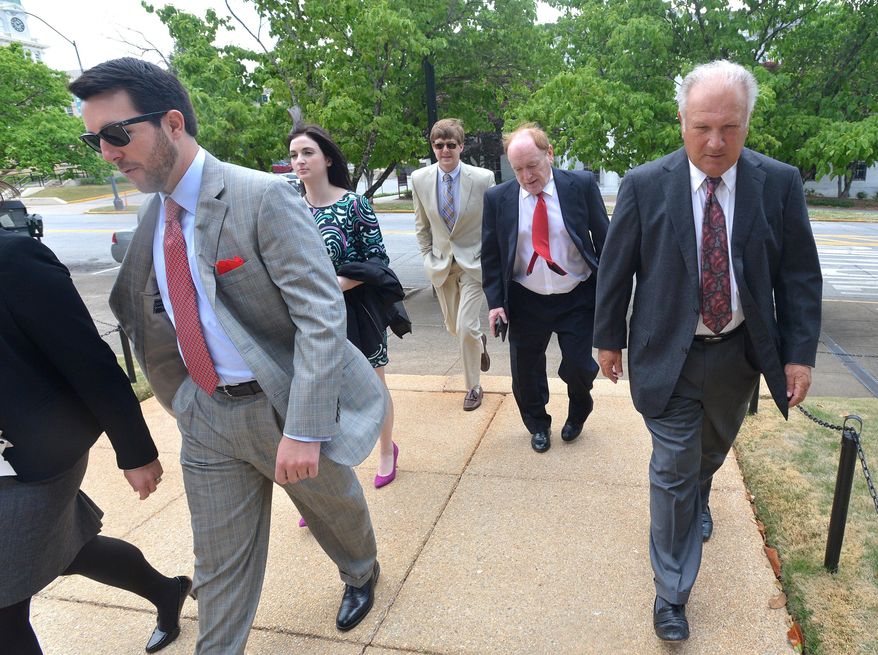 Former University of Georgia football coach Jim Donnan, right, heads into the Federal Courthouse on Wednesday, May 14, 2014, Athens, Ga. Prosecutors say the 69-year-old and another man ran a fraudulent investment scheme from September 2007 to December 2010 through GLC Limited, a West Virginia-based company dealing in wholesale and closeout merchandise. Prosecutors say the pair promised high rates of return but paid investors with other investor money. (AP Photo/Athens Banner-Herald, Richard Hamm) MAGS OUT; MANDATORY CREDIT