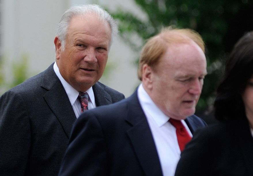 Former University of Georgia football coach Jim Donnan, left, heads into the Federal Courthouse on Wednesday, May 14, 2014, Athens, Ga. Prosecutors say the 69-year-old and another man ran a fraudulent investment scheme from September 2007 to December 2010 through GLC Limited, a West Virginia-based company dealing in wholesale and closeout merchandise. Prosecutors say the pair promised high rates of return but paid investors with other investor money. (AP Photo/Athens Banner-Herald, Richard Hamm) MAGS OUT; MANDATORY CREDIT