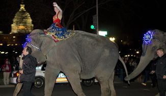 FILE - This March 19, 2013 file photo shows a performer waving as elephants with the Ringling Bros. and Barnum &amp;amp; Bailey show walk in front of the Capitol in Washington on their way to the Verizon Center. The parent company of the Ringling Bros. and Barnum &amp;amp; Bailey Circus says it has received a nearly $16 million settlement from the Humane Society of the United States and other animal-rights groups that filed a frivolous lawsuit against them. The lawsuits in federal court in Washington have dragged on for more than a decade. In 2012, a judge said the case, alleging abusive treatment of elephants, was frivolous and forced the circus&#x27; owner, Vienna, Virginia-based Feld Entertainment, to spend millions in legal fees.  (AP Photo/Alex Brandon, File)