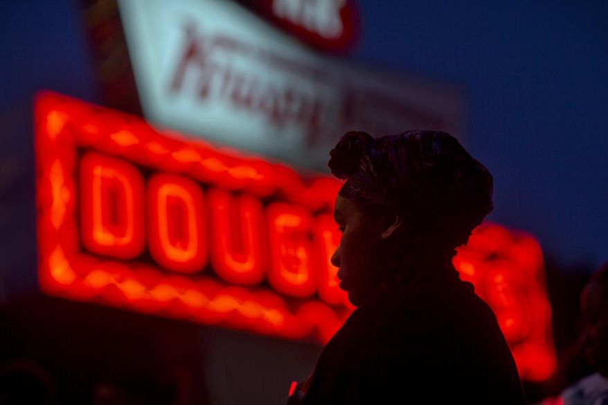 Burger King employee Keisha King, 23, stands during a protest outside a Krispy Kreme store, Thursday, May 15, 2014, in Atlanta. Calling for higher pay and the right to form a union without retaliation, fast-food chain workers in Atlanta protested Thursday as part of a wave of strikes and protests in 150 cities across the U.S. and 33 additional countries on six continents. (AP Photo/David Goldman)